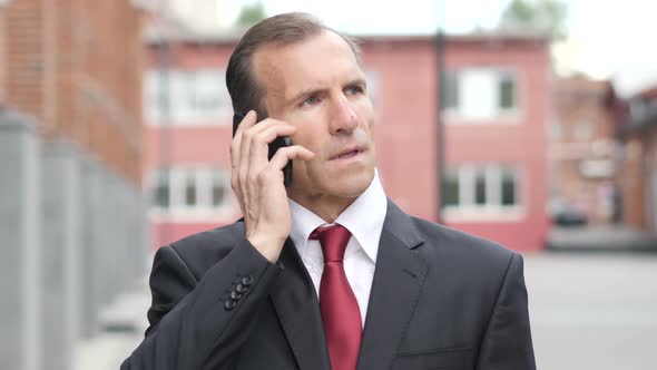 Portrait of Businessman Talking on Phone