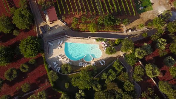 A drone takes off from a holiday pool. during a summer sunset in the Marche, Italian countryside