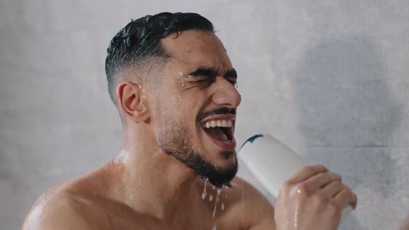 Overjoyed Happy Indian Arabian Arab Guy Singing Song in Shampoo Bottle Showering in Bathroom Having