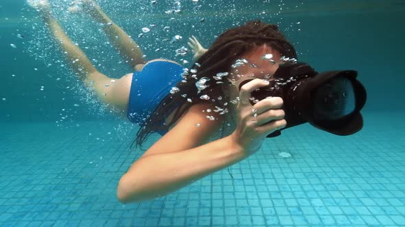 Travelling Girl in Asia. Happy Young Woman with Beautiful Long Hair Swim Under Water with Camera in