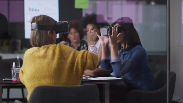 Diverse work colleagues sitting in meeting room wearing virtual reality glasses