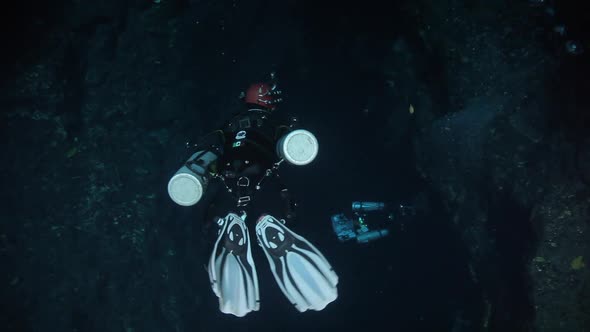 scuba diver getting in a cave in a cenote