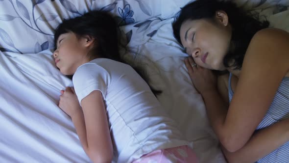 Mother and daughter sleeping together in bedroom 4k