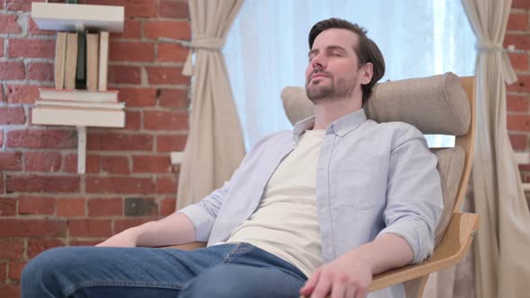 Young Man Taking Nap While Sitting on Sofa