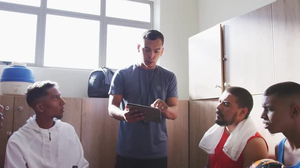 Coach talking to soccer players in the locker room