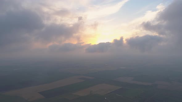 Sunset in Clouds over Farm Land