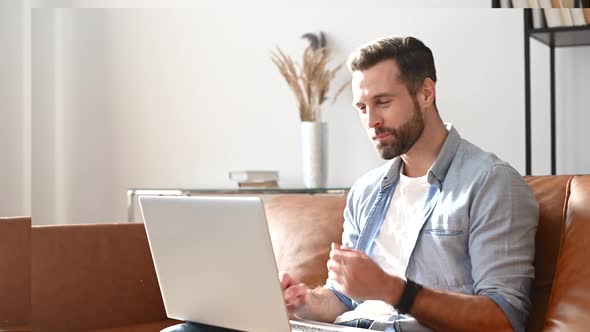 A Young Bearde Man is Using a Laptop for Video Call