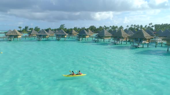 Aerial drone view of a man and woman couple on a tandem sea kayak in Bora Bora tropical island