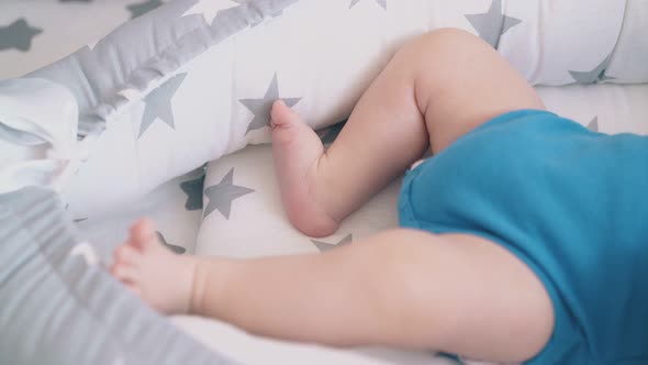 Little Boy in Bodysuit Kicks Funny Legs in Cocoon Closeup