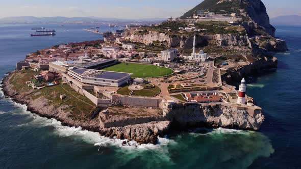 Aerial View Of Europa Point In Gibraltar With Waves Crashing Onto Rocks. Pedestal Down