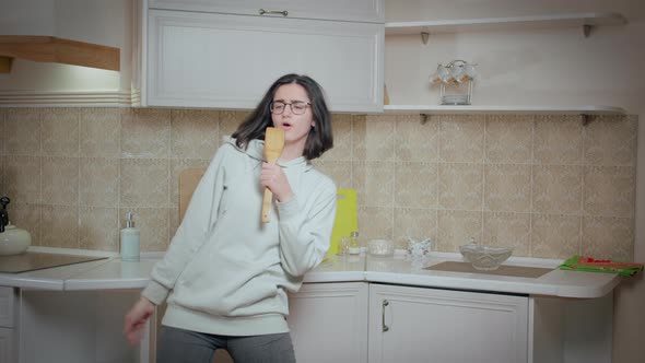 Brunette Girl in Glasses Having Fun on the Background of the Kitchen