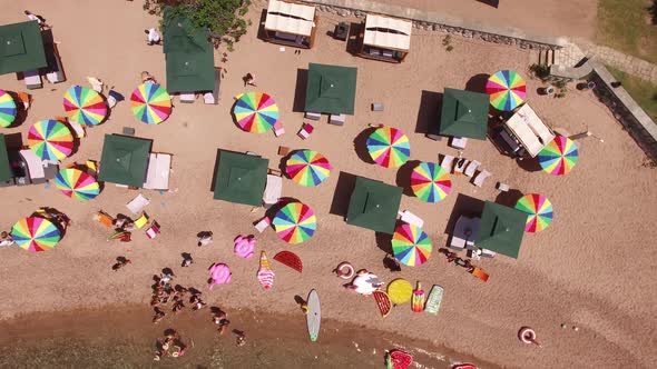 Drone View of Bright Rainbow Sun Umbrellas on Queens Beach Near Villa Milocer