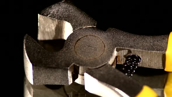 Part of Wire Cutters with Yellow, Gray Handle on Black, Reflection, Close Up, Rotation