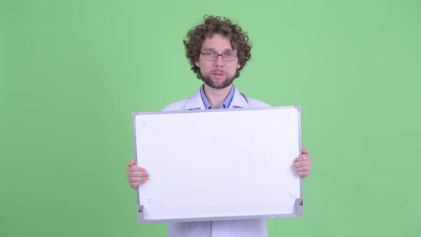 Happy Young Bearded Man Doctor Talking While Showing White Board