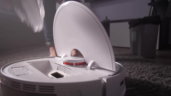 Woman Maintaining Work of Robotic Cleaner at Home