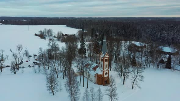 Aerial Top View of the Krimulda Evangelic Lutheran Church in Winter at Sunrise Latvia 4k Video