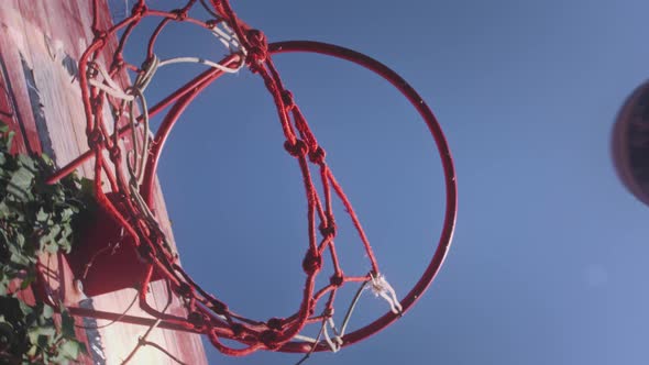 Upward View a Basketball Ball Hits the Basket in the Sports Yard