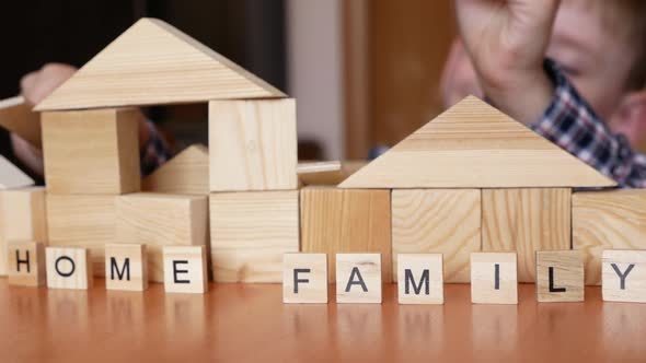 Home and family are real values. Active preschooler caucasian boy builds a house from wooden cubes.