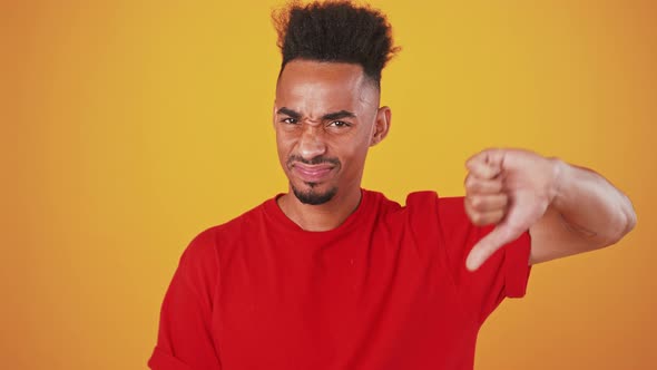 Grumpy African American Guy Showing Thumb Down Gesture