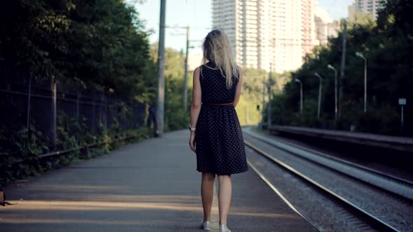 Woman In Dot Dress Walking On Railroad Station Platform. Girl Waiting Train On Public Transport.