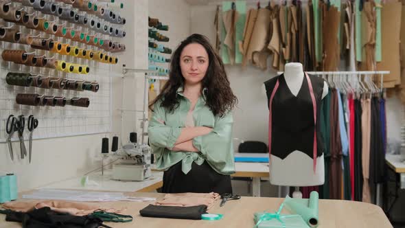 female fashion professional designer standing at work-desk in cozy office studio.