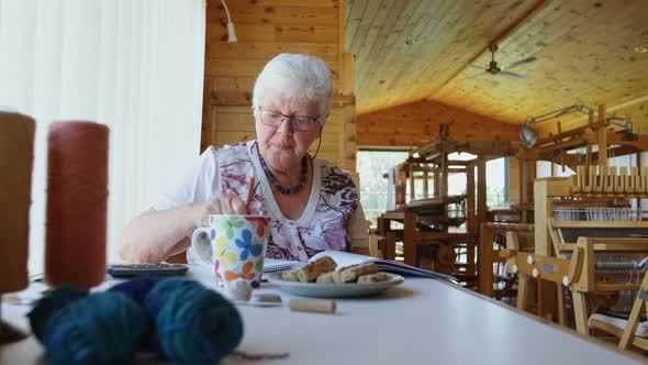 Senior woman sitting on the table and calculating