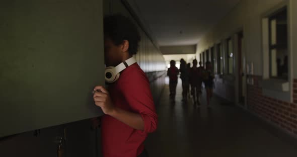 Boy opening his locker in the school