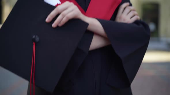 Pedestal Shot of Slim Beautiful Brunette Woman with Grey Eyes in Graduation Toga Looking Away