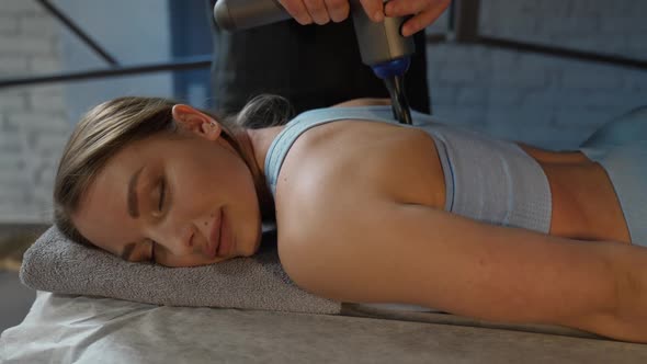 An Osteopath Performs Back Massage to a Young Female with a Massager Female Enjoy a Massage Neck and