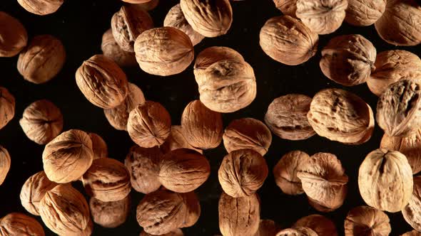 Super Slow Motion Closeup Shot of Flying Whole Walnuts Towards Camera Isolated on Black at 1000Fps