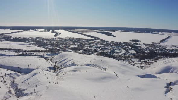 The Village Appears From Behind the Snowy Mountains on a Bright Sunny Day