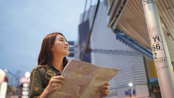 Asian young woman backpacker traveler look at map to find destination.
