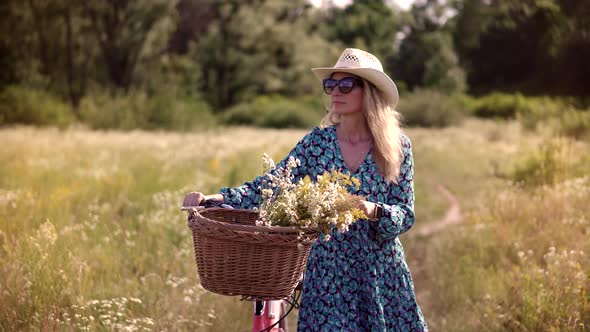 Girl In Hat Enjoying Weekend. Woman Cyclist Walking With Bike On Holiday Vacation Trip. Wildflower.