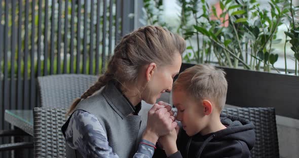 Mom Hugs Her Baby. Woman With Child Spending Time In Cafe