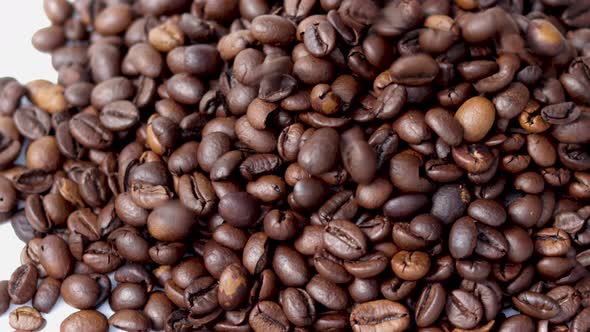 freshly roasted coffee beans falling from pack on table,flat surface,pouring from up down.sunny rays