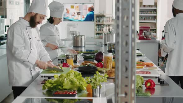 Portrait of Man in Uniform Preparing Green Salad on Cutting Board