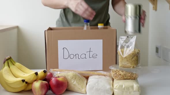 Woman Puts Food Products in Donation Box