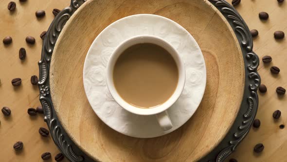 Top View of Coffee with Milk on Decorative Plate on Wooden Table