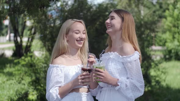 Two Pretty Girls Drinking Takeaway Drinks