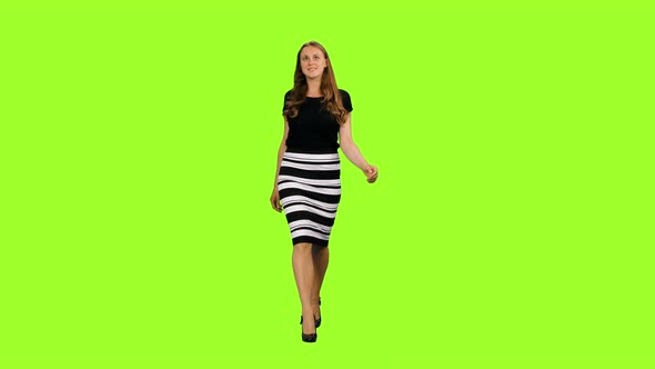 Beautiful Woman in Black Blouse and Striped Skirt Walks on Green Background, Chroma Key