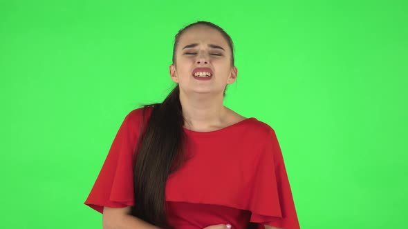 Portrait of Pretty Young Woman Is Feeling Very Bad, Her Stomach Hurting. Green Screen