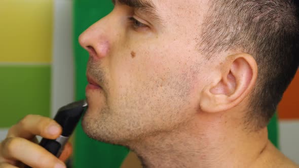 Closeup of a Man Shaving with an Electric Trimmer Razor