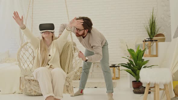 Young Caucasian Entrepreneur Showing His Blondhaired Fiancee the Technology Behind VR Glasses in