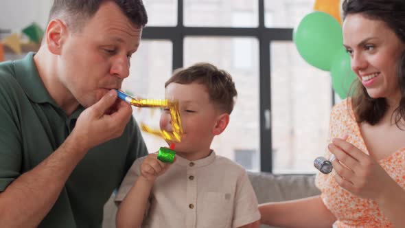 Happy Family with Party Blowers Having Fun at Home