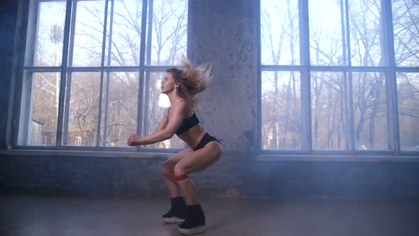 Sporty Woman Doing Jump Squats with Elastic Band