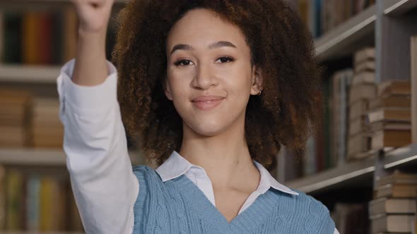 Headshot Happy Female Student Standing in University Library Smiling Looking at Camera Showing Thumb