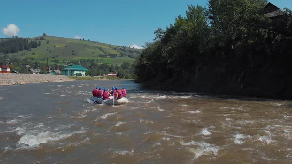 People in Helmets and Vests Kayaking on River