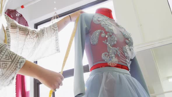 Fashion designer measuring dress on dressmakers model 4k