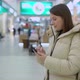 Young Woman in Shopping Mall or Trade Center Using Smartphone Mobile Phone - VideoHive Item for Sale