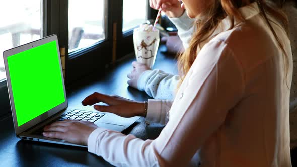 Woman siting in a restaurant and using laptop